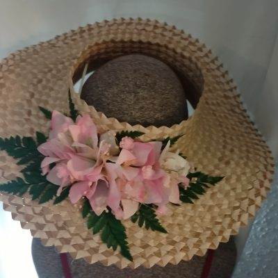 Chapeau tressé bougainvilliers roses pâles sur fougères